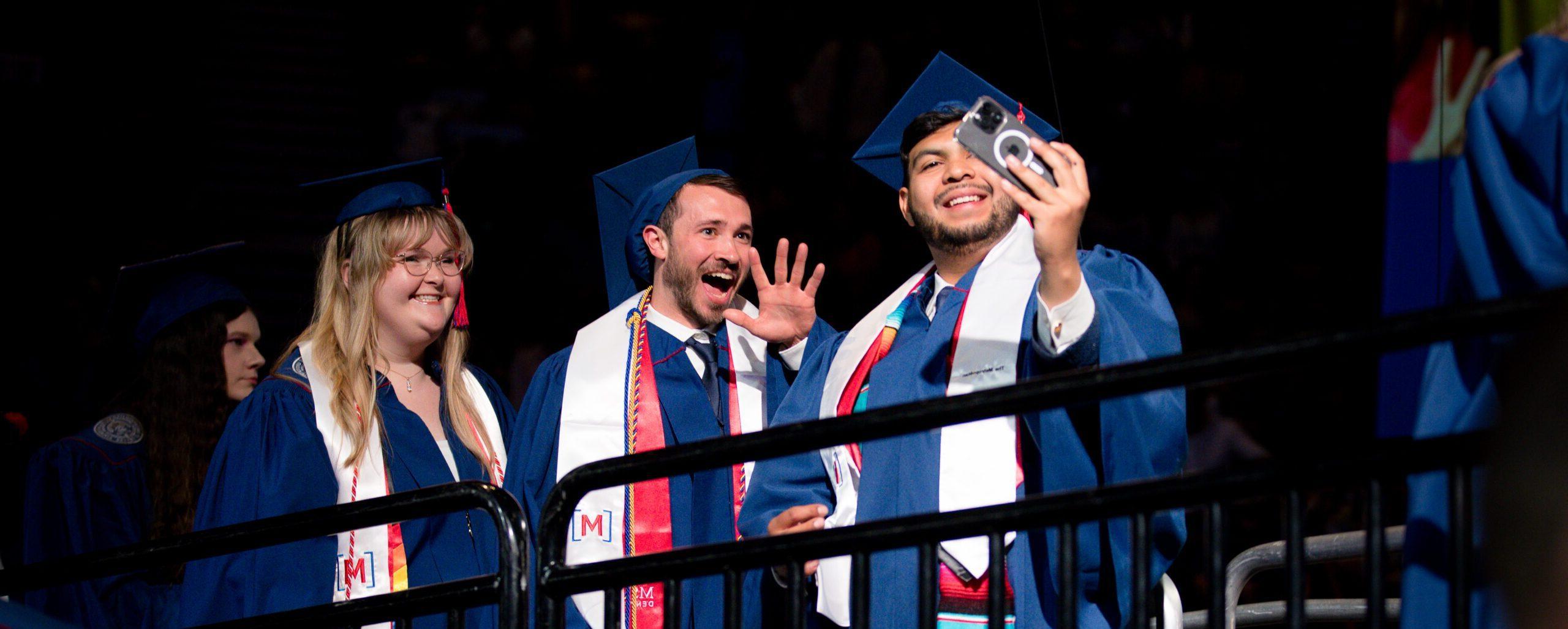 Grads take a celebratory selfie before they cross the stage at Commencement